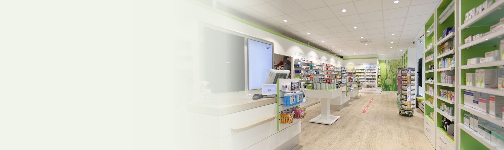 Eine helle, moderne Apotheke mit gut sortierten Regalen und einem einladenden Verkaufsbereich.